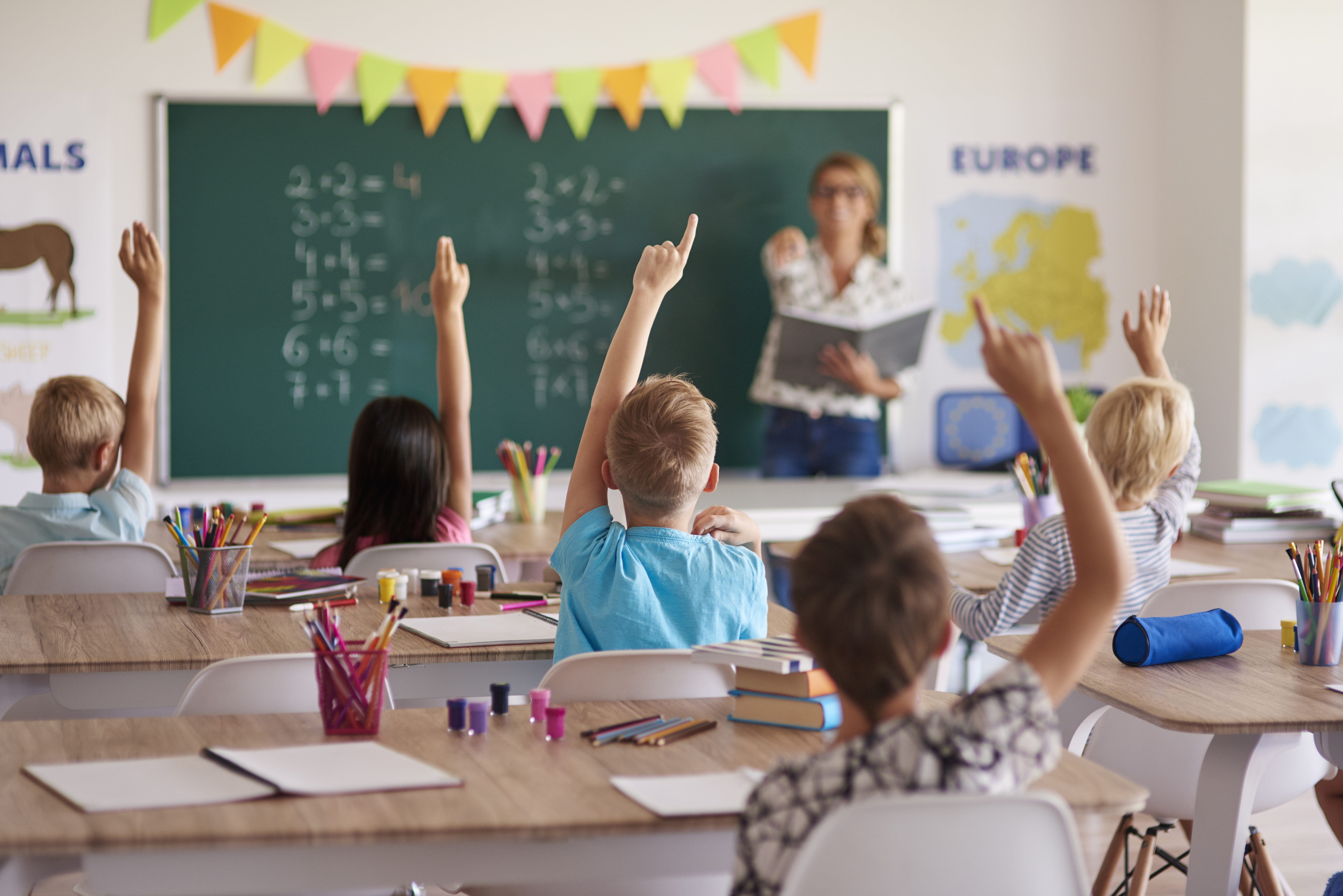Estudiantes levantando la mano en clase